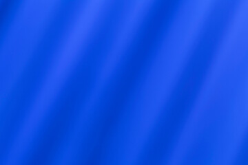Abstract blue smooth soft blur fabric background with wavy curves for illustration.