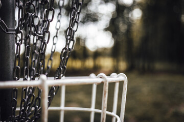 white disc golf basket with blurred background