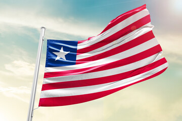 Liberia national flag waving in beautiful clouds.