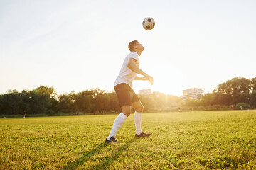 Forest on background. Young soccer player have training on the sportive field