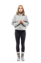 Cute funny young woman making holding breath grimace with puffed blowing cheeks. Full body portrait...