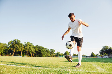 Summer daytime. Young soccer player have training on the sportive field