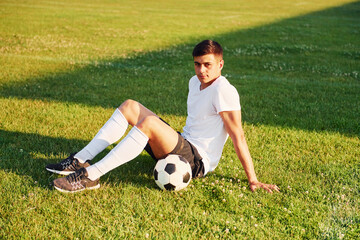 Takes a break. Young soccer player have training on the sportive field