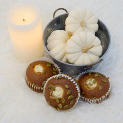 A peaceful setting of cupcakes and gourds on a bedroom serving table.