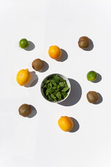 Photo of ingridients for refreshing summer lemonade cocktail  with fresh citrus lime lemon and green mint and cocktail bar tools outdoors with white background flat lay style
