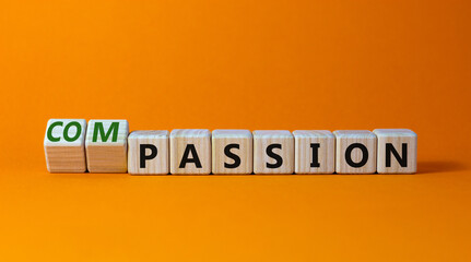Passion or compassion symbol. Turned wooden cubes and changed the word compassion to passion. Beautiful orange table, orange background, copy space. Business, passion or compassion concept.