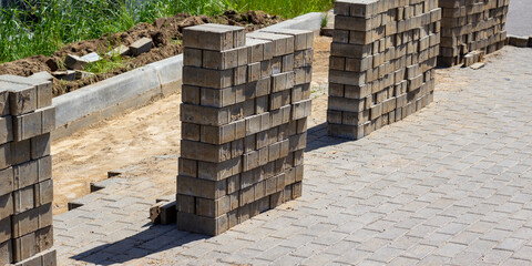 Pile of concrete cement cinder blocks at the construction site. Sidewalk construction and reconstruction. Beautiful grey background. Reconstruction concept image.