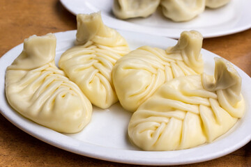 Traditional Georgian cuisine symbol. Georgian traditional Khinkali with cheese on white plate. Traditional Georgian cuisine concept.