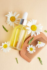 Obraz na płótnie Canvas Organic vegan natural cosmetics for hair. Flat Lay composition of Chamomile flowers and cosmetic bottles with essential oil. Natural beauty. top view. Space for text
