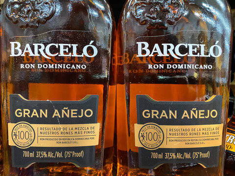 Viersen, Germany - July 9. 2021: Closeup of bottle label with logo lettering of dominican barcelo rum in shelf of german supermarket (focus on upper part of right label)