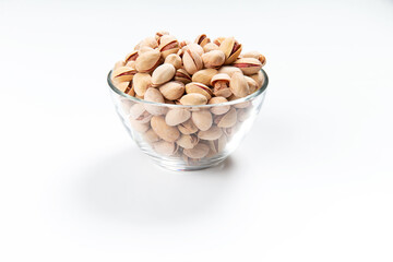 Pistachios in a glass cup on a white background. Close-up.