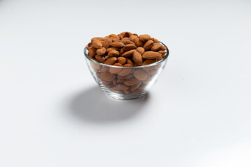 Almonds in a glass cup on a white background. Close-up.