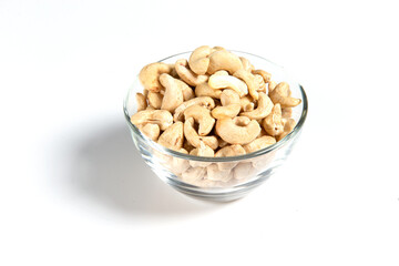 cashews in a glass cup on a white background. Close-up.