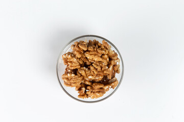 Walnut in a glass cup on a white background. Close-up.