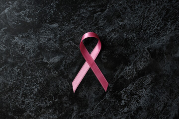 Breast cancer awareness ribbon on black smokey background