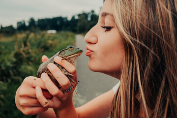 girl about to kiss a frog 