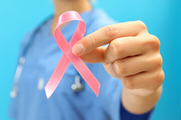 Nurse with breast cancer awareness ribbon, close up