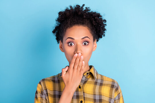 Photo of young afro woman cover lips hand oops fail speak secret worried nervous isolated over blue color background