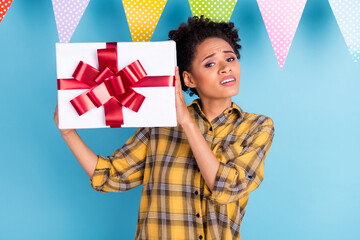 Photo of young black girl unhappy negative moody hold present dislike isolated over blue color...