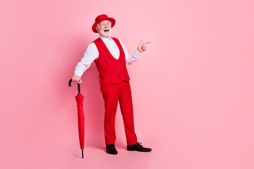 Full length photo of aged man happy positive smile hold umbrella point finger empty space ad promo...