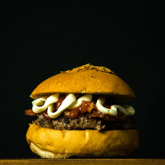 Tasty Fresh Home Made Gourmet Burger on Wooden Table With Dark Background