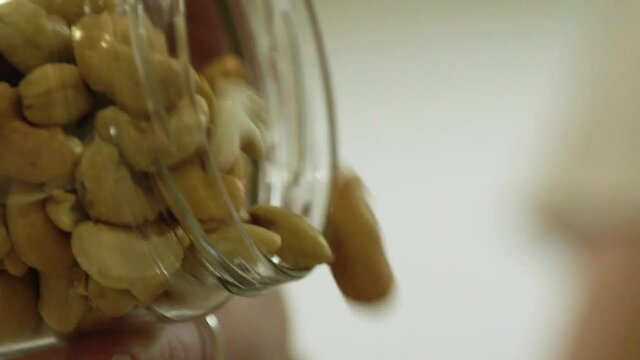 pouring peanuts into a bowl in slow motion ready for baking dessert in lockdown close up