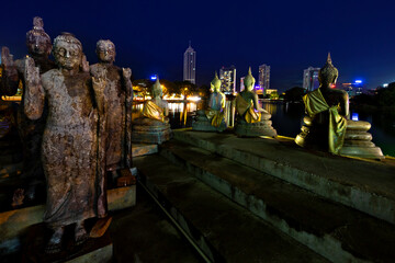 Buddha statues in Seema Malaka temple and skyline of Colombo, Sri Lanka