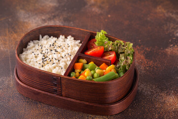 Healthy lunch in wooden japanese bento box.