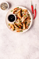 Fried dumplings served with green onions, sesame seeds and chili peppers
