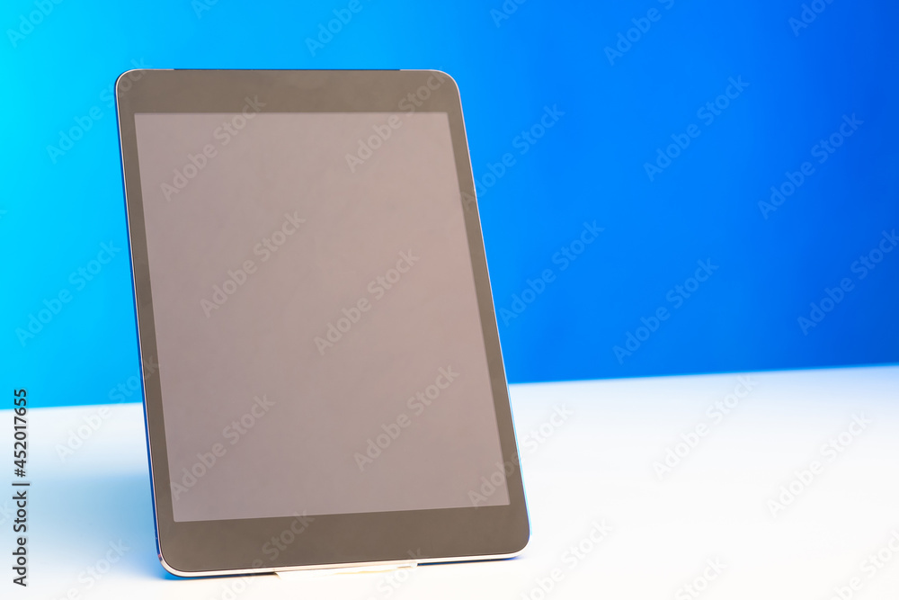 Poster technology device with an empty display. tablet computer on a white table. electronic tablet on a wh