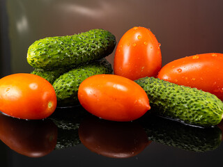 tomatoes and cucumbers on a dark background with splashes of water