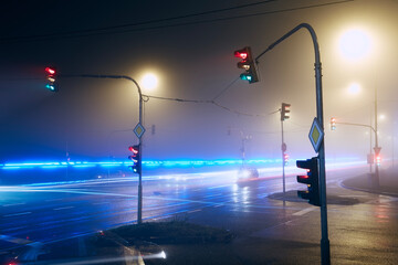 Light trail of emergency ambulance passing crossroad at foggy night.. © Chalabala