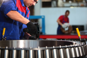The large diameter bearing is assembled at the factory. The worker assembles the bearing by hand....