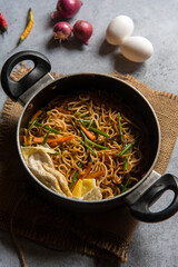 Hot wok schezwan  noodles prepared with chopped vegetables and udon noodles. View from top.