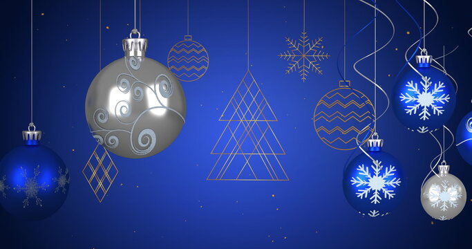 Image of christmas blue and silver baubles and decorations hanging with snow falling