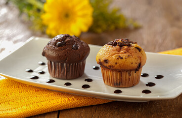 muffins de chocolate e baunilha com gotas de chocolate em fundo decorado.