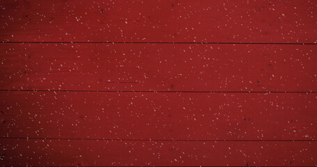 Image of winter scenery snow falling against red wooden boards