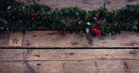 Image of christmas decoration with snow falling on wooden boards
