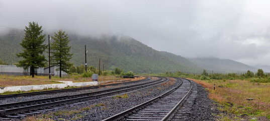 Rainy day in the Ural mountains. Railways beyond the Arctic Circle hidden by fog.