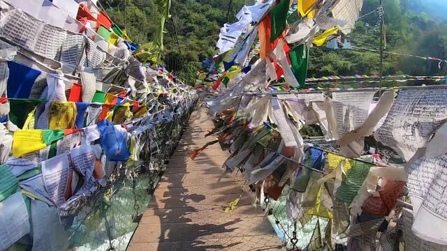 suspension iron bridge with many buddhist holy flags from different perspective