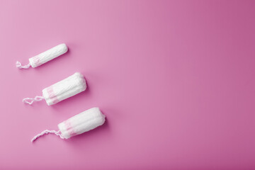 Cotton tampons on a pink background with a free space