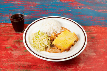 mashed potato pie with chicken and sautéed cabbage leaves and accompanying rice