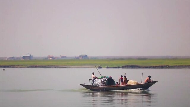 A group of people on a trawler boat in the Padma river in Bangladesh.