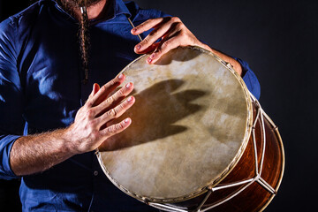 Closeup drummer male hands with jembe. Man is drumming on wooden ethnic drum. Percussion musical...