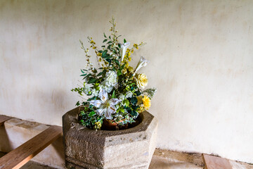 Flowers in stone vessel in old church.
