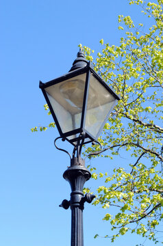 Traditional Iron Street Light seen from Below against Blue Sky 