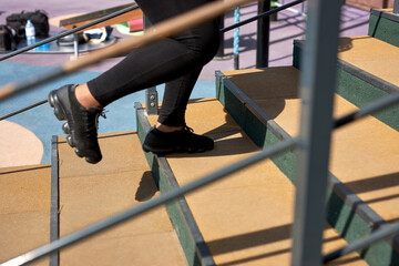cropped african woman running up stairs with concentrated motivated expression, doing cardio...