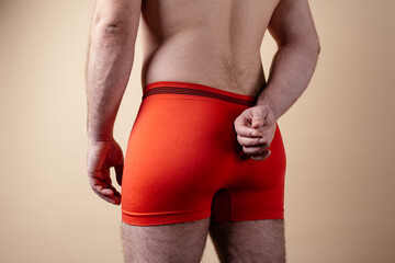 body parts: a sporty male ass in colored underpants. concept: men's health and sexuality. a hairy man on a paper background. model test © skeronov