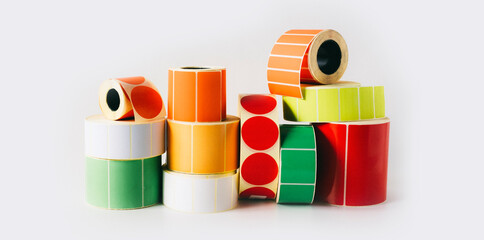 Colored and white reels with self-adhesive labels for printers.