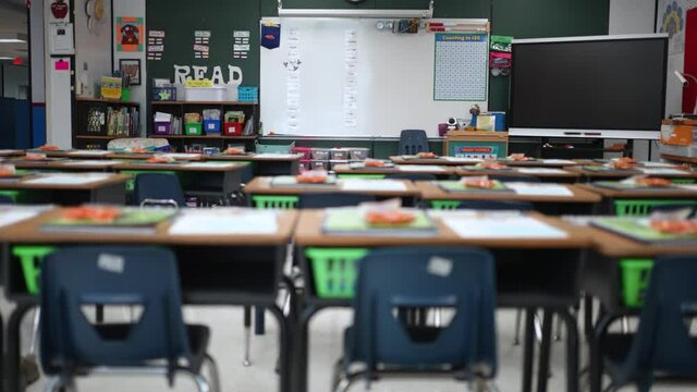 Camera slide to right showing empty school classroom with interactive whiteboard no people during pandemic.